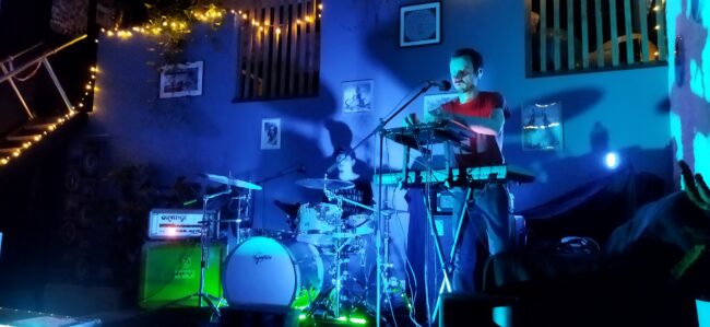 Le groupe Fire Life en concert privé à Roubaix. Mimmo à la batterie à gauche, Arnaud aux claviers à droite. Baigné dans une lumière bleue.
